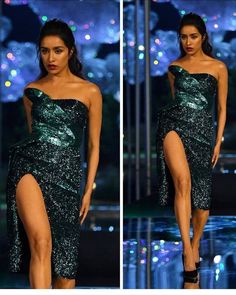 a model walks down the runway in a green dress with thigh high slits and an asymmetrically shaped skirt