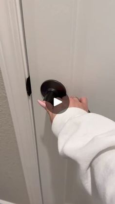 someone is opening the door with a black knob on their thumb and pulling it out