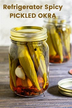 two jars filled with pickled okra sitting on top of a table next to coins