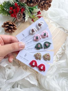 a person is holding four small bows in front of some pine cones