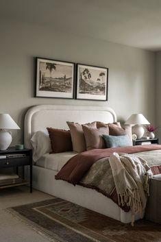 a large bed sitting in a bedroom next to two pictures on the wall above it