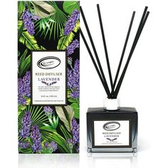 reed diffuser in front of a box with purple flowers and leaves on the inside