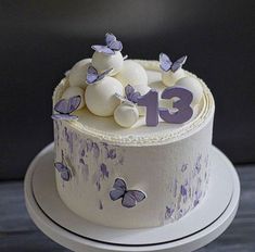 a white cake with purple butterflies and the number 31 on it's top tier