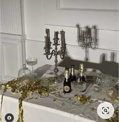 a table topped with bottles of champagne and confetti on top of a table