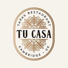 the logo for tapas restaurant tu casa cambridge, uk is shown in brown and white