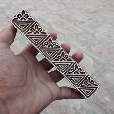 a hand holding an intricately designed metal object