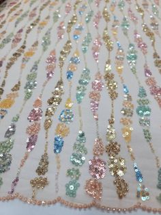 sequins and beads on white fabric with gold trim