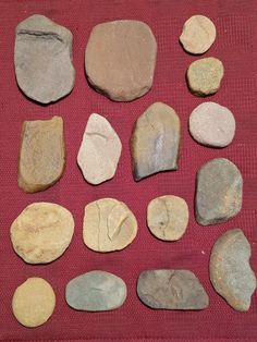 several different types of rocks laid out on a red cloth