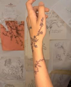 a woman's arm with flowers on it and writing on the back of her arm