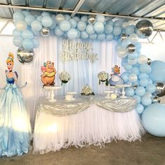 there is a table with balloons and cake on it at a birthday party in the shape of disney princesses