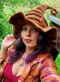 a woman with purple hair wearing a brown hat