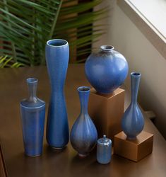 blue vases and containers are sitting on a table