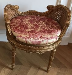 an ornate chair with a red and white cushion