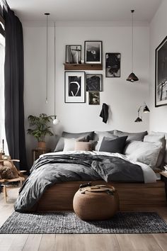 a bedroom with black and white decor, pictures on the wall and wooden flooring