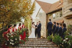 a bride and groom standing at the alter with their wedding party in front of them