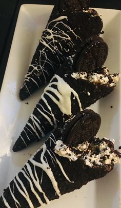 three oreo cookies with white icing on a plate