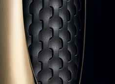 the back end of a black and gold motorcycle seat with an intricate design on it