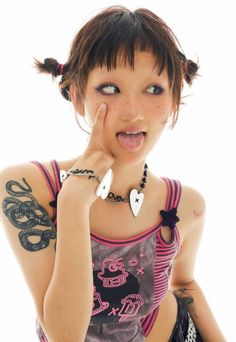 a woman with tattoos making a funny face while holding her hand to her mouth and looking at the camera