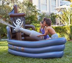 two children playing in an inflatable pirate ship