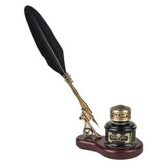 a pen and quill sitting on top of a wooden stand next to a black feather