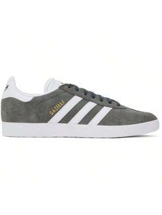 adidas Originals 
Gray & White Gazelle Sneakers 
Low-top nubuck and buffed faux-leather sneakers in gray and white. 
. Lace-up closure 
. Logo embossed at padded tongue 
. Padded collar 
. Signature serrated stripes at sides 
. Logo stamp at outer side 
. Logo bonded at heel tab 
. Padded footbed 
. Mesh lining 
. Textured treaded rubber sole 
Supplier color: Solid grey/White/Gold metallic 
Upper: leather, synthetic. Sole: rubber. 
Made in Viet Nam. 
241751M237065 
Originals Gray & White Gazelle White Gazelle, Casual Athletic Shoes, Logo Stamp, Outdoor Shoes, Leather Sneakers, Gray White, Low Top, Adidas Originals, Outdoor Sports