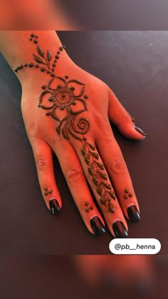 a woman's hand with henna tattoos on it