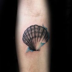 a black and white photo of a sea shell on the right arm with blue ink