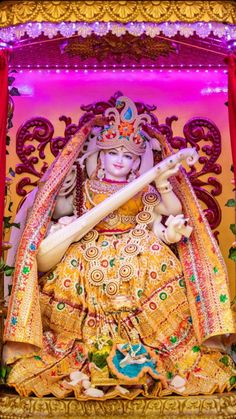 an idol is displayed in front of a red curtain