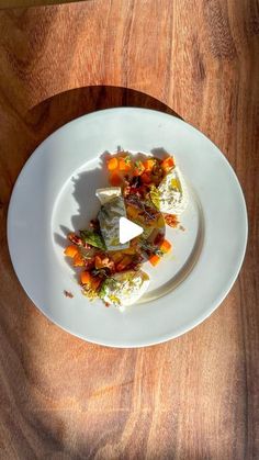 a white plate topped with food on top of a wooden table