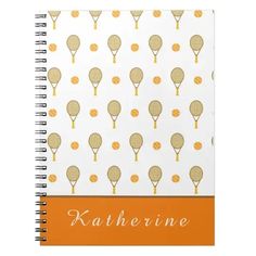 an orange and white notebook with tennis rackets on the front, in gold foil