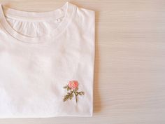 "Hand Embroidered women shirt with a flower. A beautiful t-shirt made of organic cotton. Discover its incredible soft touch and you will never want take it off. T-SHIRT DETAILS The sleeve is short and the neck is ribbed. SIZES: From XS to L (if you are looking for another one, ask me by message). It is an oversized t-shirt. The size of the photos is an S, it is not adjusted so I recommend you use the size you usually use or perhaps one less. The length is up to the hip approximately. You can che Luxury Embroidered Cotton T-shirt, Cheap Pink Floral Embroidered T-shirt, Cheap Pink Embroidered T-shirt, Flower T Shirt, Embroidered Designs, T Shirt Flowers, Slogan Tshirt, Customise T Shirt, Inspirational Shirt