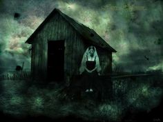 a woman sitting in front of a wooden building on a field with dark clouds behind her