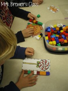 two children are playing with legos on the table at their school's desk