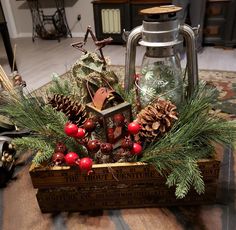 a christmas centerpiece with pine cones, berries and an old fashioned lantern on a coffee table