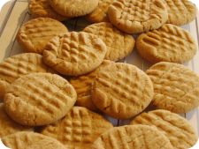 some cookies that are sitting on top of each other in front of a plate full of them