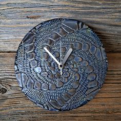 a clock that is sitting on the side of a wooden table with water droplets all over it