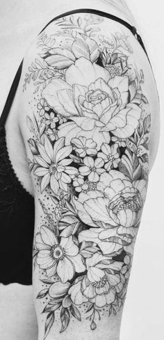 a woman's back with flowers and leaves on her arm, in black and white