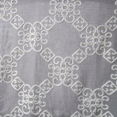 an embroidered fabric with white lace on grey background, suitable for use in curtains and upholstering