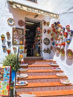 the entrance to an artisan shop with plates on the wall and decorations on the steps