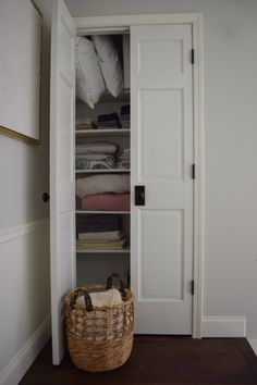 an open closet door with a basket in it