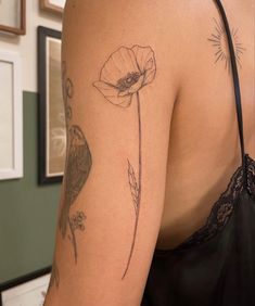 a woman's arm with tattoos on it and a flower in the middle of her arm