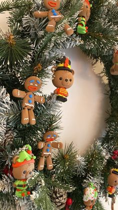 a christmas wreath decorated with gingerbread men and women hanging from it's sides