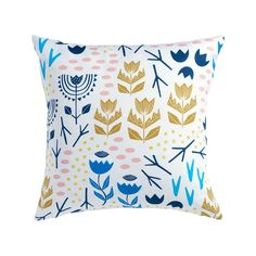 a white pillow with blue and gold flowers on it, against a white background that has polka dots