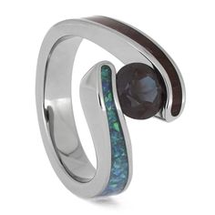 Choose a colorful and nature-inspired engagement ring to pop the big question! This handmade titanium ring is inlaid with purple heart wood and synthetic opal, which swirl around the stunning alexandrite center stone. The titanium construction makes this ring a sturdy and hypoallergenic choice for any nature lover. RING LAYOUTRing Width: 10 mm Tapered to 4 mmRing Sleeve: TitaniumRing Profile: Flat, Tension SettingRing Finish: Polished 0.75 mm Titanium 2.5 mm Partial Purple Heart Wood and Synthetic Opal OP730.75 mm Titanium Stone (Qty: 1): Alexandrite (Lab-created), Shape/Size: Round, 5 mm Setting: Tension Colorful Engagement Ring, Purple Heart Wood, Jewelry By Johan, Nature Inspired Engagement Ring, Heart Wood, Colored Engagement Rings, Titanium Ring, Synthetic Opal, Titanium Rings