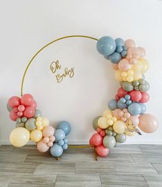 the balloon arch is decorated with pastel colors