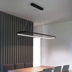 a dining room table with four chairs and a light fixture hanging from the ceiling over it