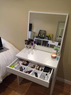 a bedroom with a bed, mirror and desk in the corner that has drawers underneath it