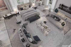 an aerial view of a living room with grey couches and white rugs on the floor