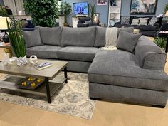 a living room filled with furniture and lots of pillows on top of a rug in front of a coffee table