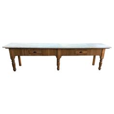 a wooden table with two drawers and marble top